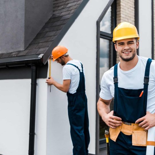 selective-focus-of-happy-handyman-in-uniform-near-coworker.jpg